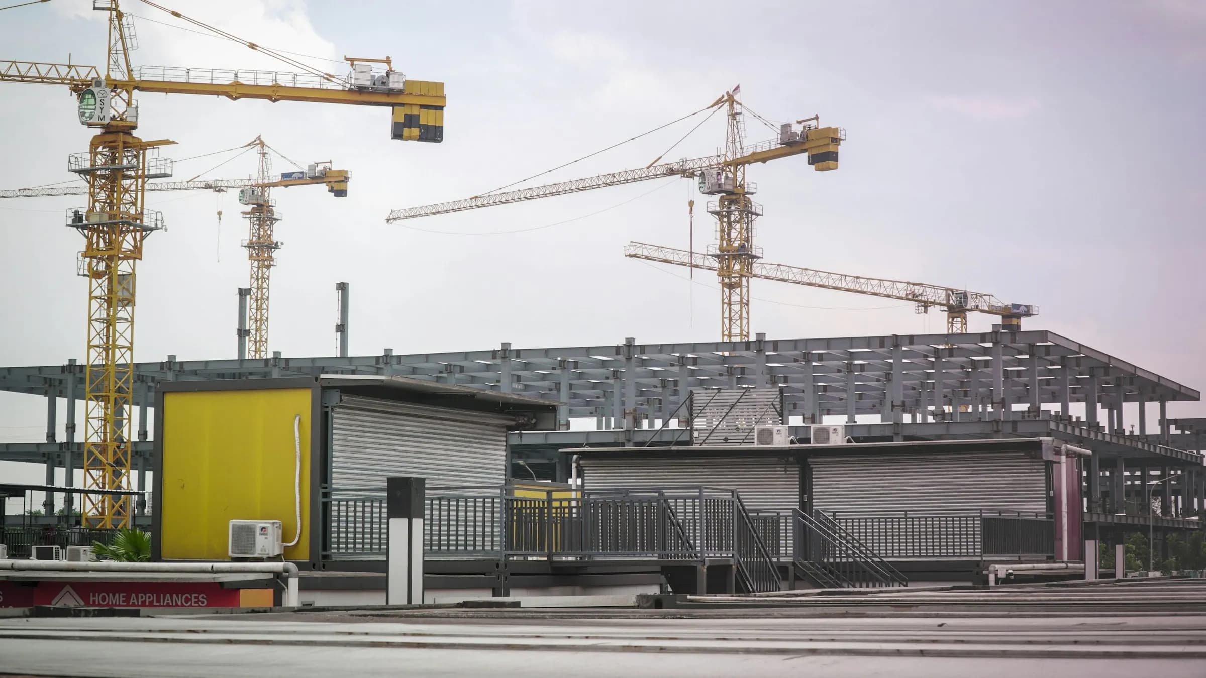 Tower cranes over a building's structural frame under construction