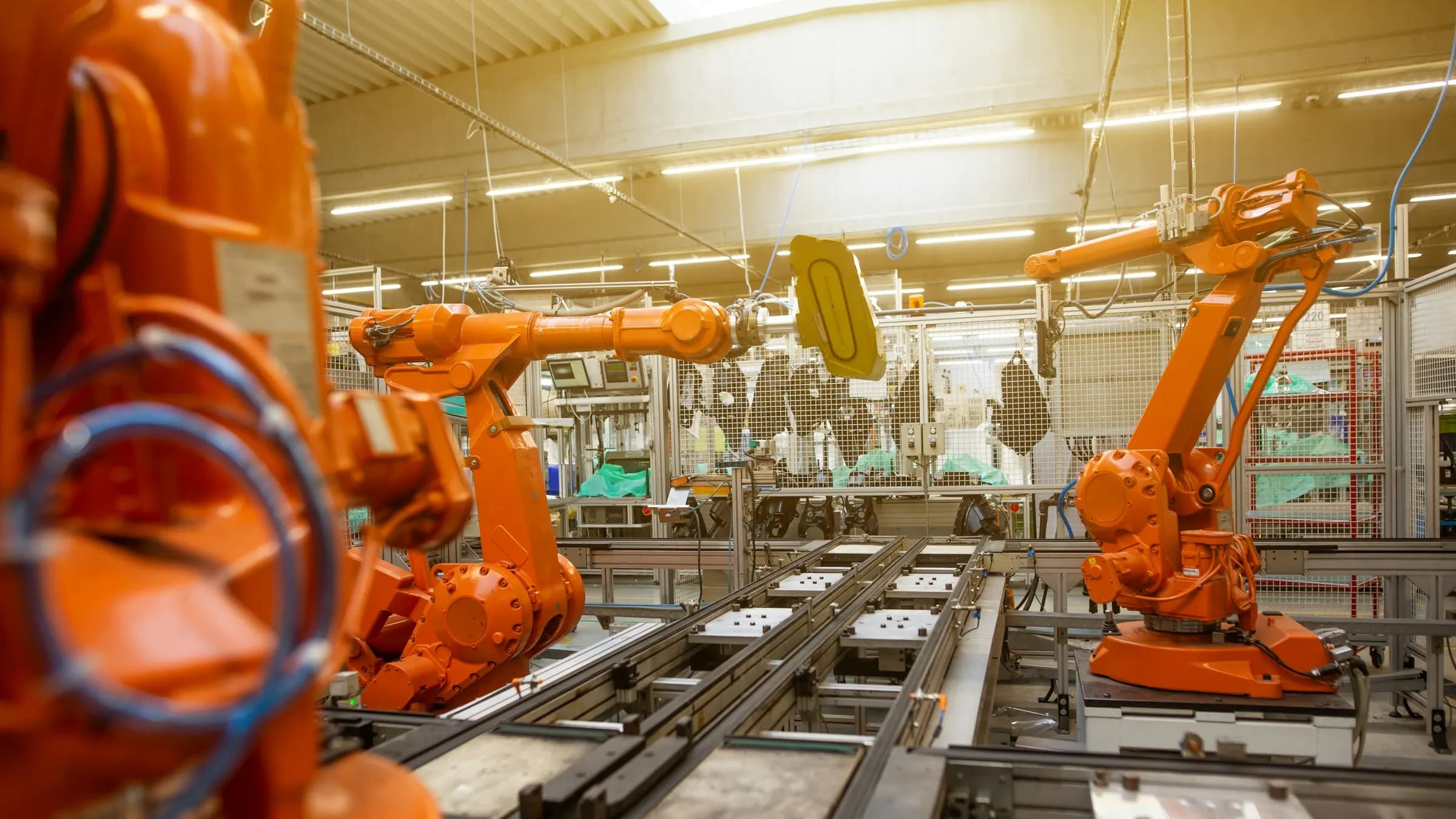 Rows of orange robotic arms on a manufacturing production line