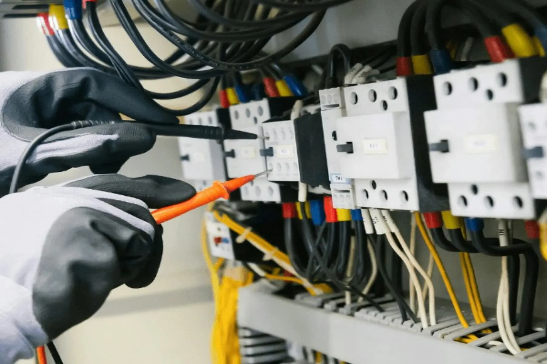 Technician testing an electrical panel with a multimeter